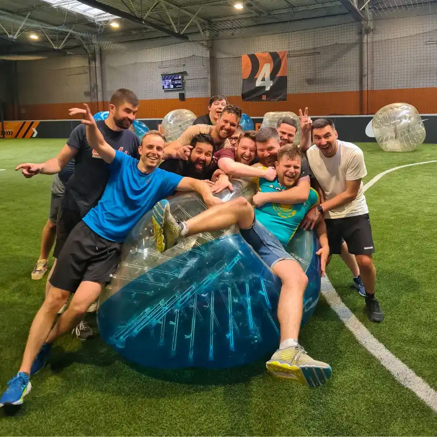 Groupe d’adultes réuni autour de bulles de Bubble Foot sur un terrain UniGames