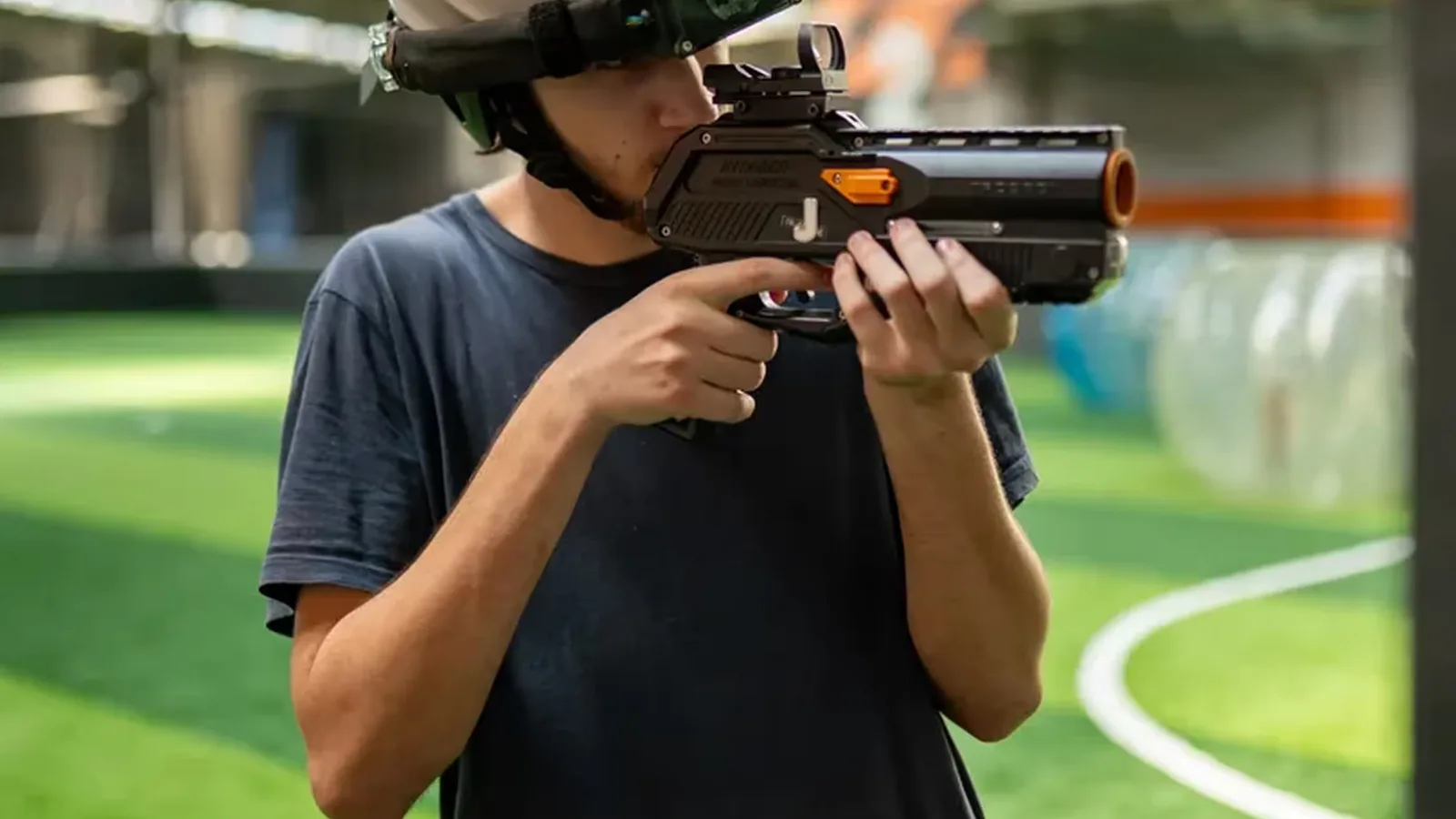 Joueur UniGames visant avec un pistolet de Laser Game équipé d’un viseur holographique