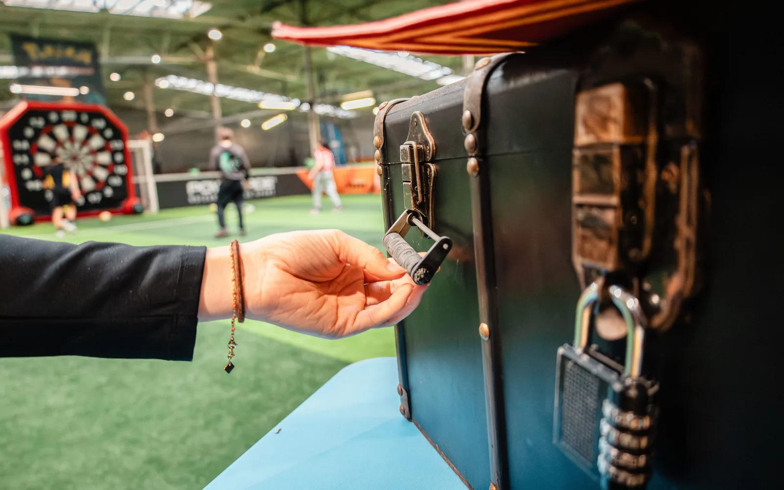 Main ouvrant une malle d’Escape Game UniGames avec un cadenas