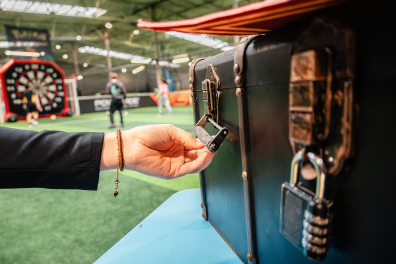 Une main manipule le cadenas d’une mallette de jeu